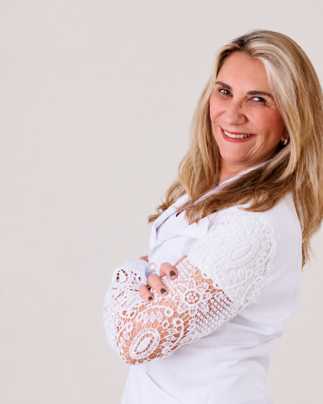 Dra. Márcia Magacho em retrato profissional, com os braços cruzados e expressão acolhedora